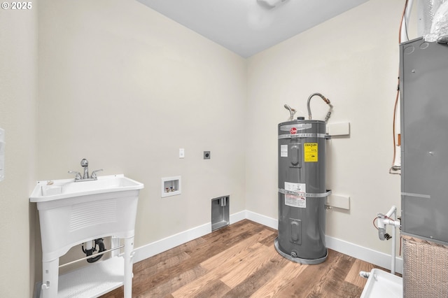 washroom featuring sink, wood-type flooring, hookup for a washing machine, hookup for an electric dryer, and water heater