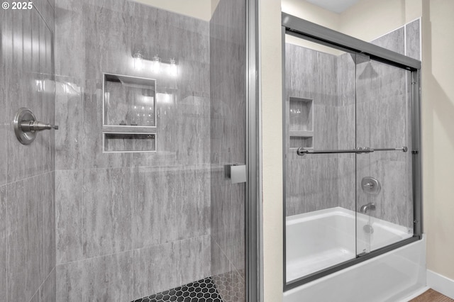 bathroom featuring bath / shower combo with glass door