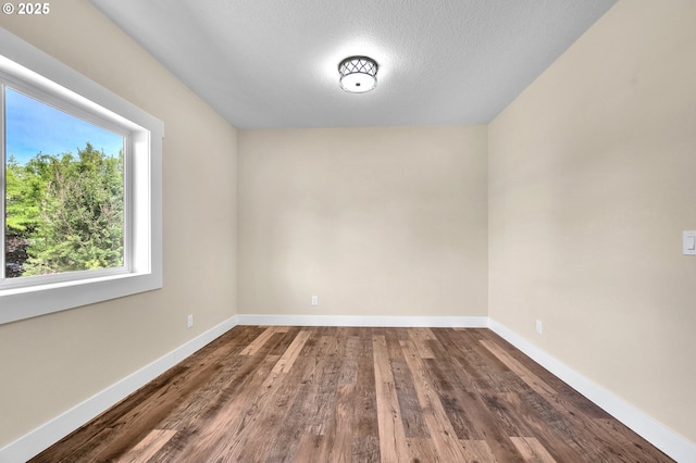 unfurnished room featuring hardwood / wood-style flooring and a textured ceiling