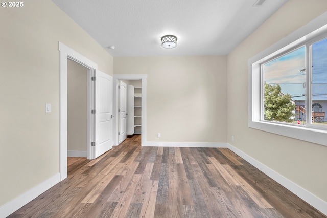 unfurnished room with dark hardwood / wood-style floors and a textured ceiling