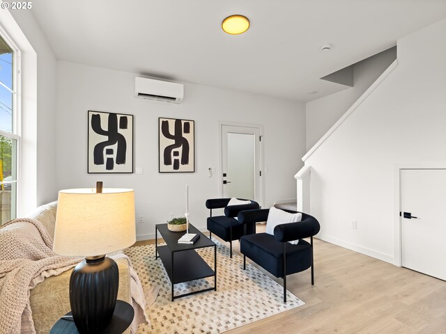 7040 N Leonard Ave, Portland, OR 97203 - sitting room featuring an AC wall unit, light wood finished floors, stairs, and baseboards