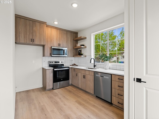 7040 N Leonard Ave, Portland, OR 97203 - kitchen with stainless steel appliances, a sink, light wood finished floors, decorative backsplash, and open shelves