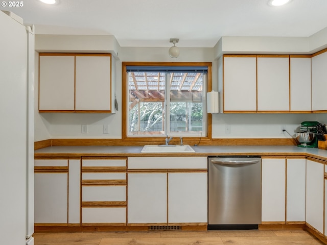 kitchen with visible vents, dishwasher, light wood-style flooring, freestanding refrigerator, and a sink