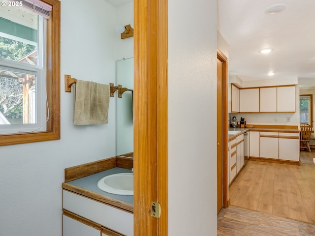 bathroom featuring wood finished floors, vanity, and recessed lighting