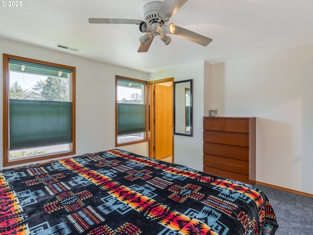 bedroom with carpet, visible vents, a ceiling fan, a textured ceiling, and baseboards