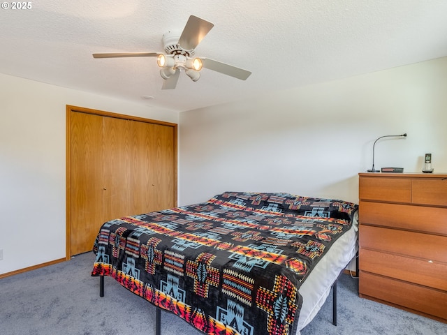 bedroom featuring carpet floors, a closet, a textured ceiling, and baseboards