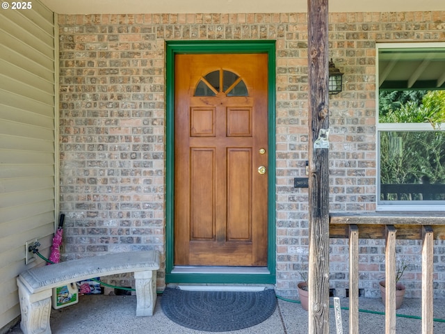 doorway to property with brick siding