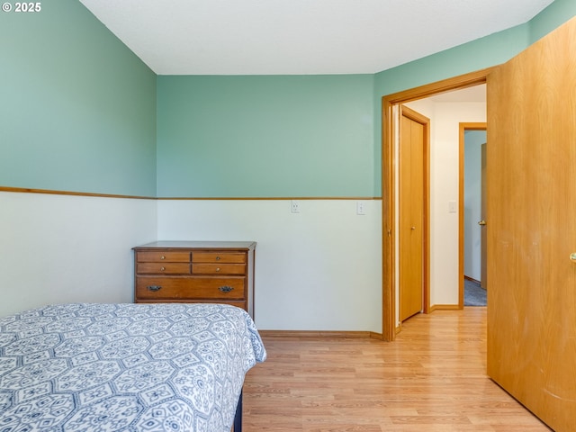 bedroom with light wood-type flooring and baseboards