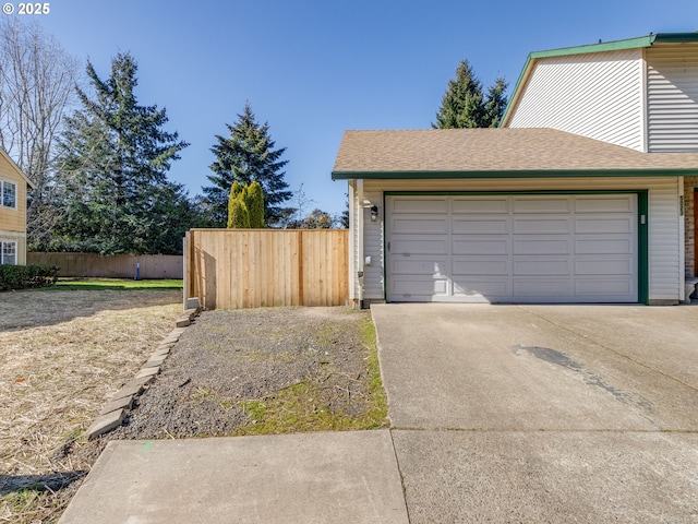 garage with driveway and fence