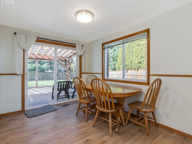 dining area featuring visible vents, hardwood / wood-style flooring, and baseboards