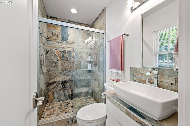 bathroom with toilet, a stall shower, and vanity