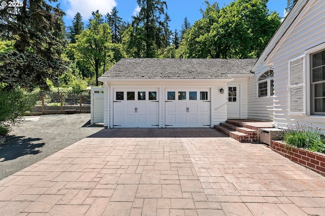 garage featuring fence and driveway