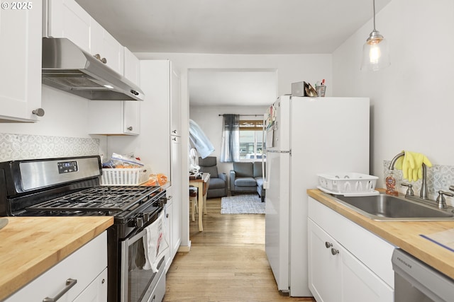 1510 W 10th St, The Dalles, OR 97058 - kitchen with stainless steel appliances, butcher block counters, under cabinet range hood, and light wood-style floors