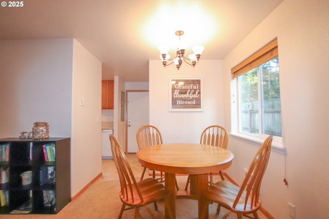 dining area with light colored carpet and a notable chandelier