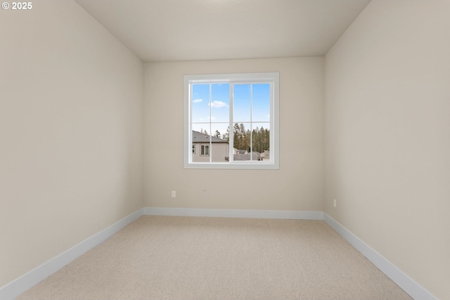 carpeted empty room featuring baseboards