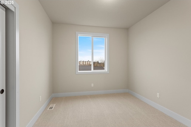 spare room with light carpet, baseboards, and visible vents