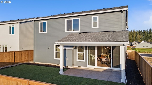 rear view of house featuring a yard, a fenced backyard, roof with shingles, and a patio