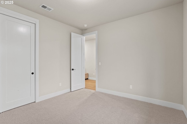 unfurnished bedroom with carpet, visible vents, and baseboards