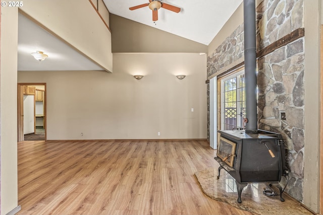 151 Owl Creek Rd, Kelso, WA 98626 - living area with baseboards, ceiling fan, high vaulted ceiling, wood finished floors, and a wood stove