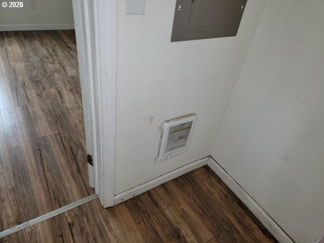 living area with a textured ceiling, baseboards, and dark wood-type flooring