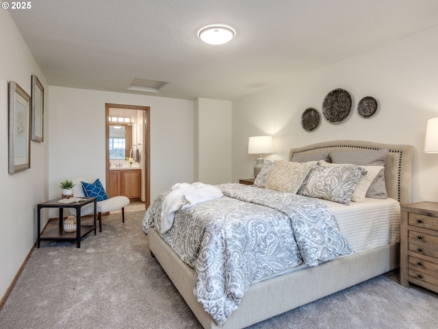 carpeted bedroom with ensuite bathroom, attic access, and baseboards
