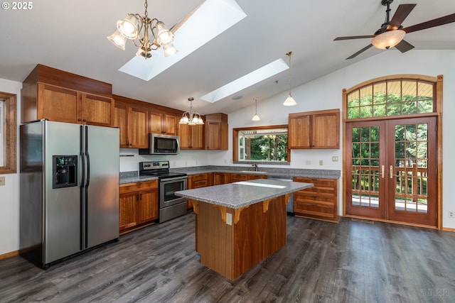 25363 Wonderly Rd, Rainier, OR 97048 - kitchen with stainless steel appliances, a skylight, brown cabinets, a chandelier, and dark wood-type flooring
