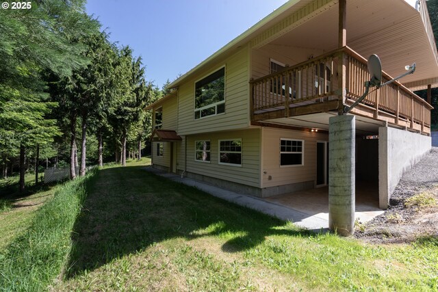 25363 Wonderly Rd, Rainier, OR 97048 - back of property featuring a yard, a wooden deck, and a patio area