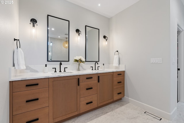 full bath featuring baseboards, double vanity, recessed lighting, and marble finish floors