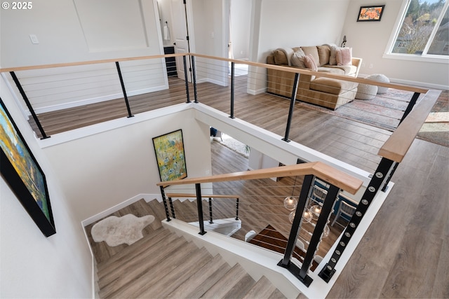stairs featuring wood finished floors and baseboards