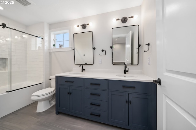 full bathroom with toilet, double vanity, enclosed tub / shower combo, and tile patterned flooring