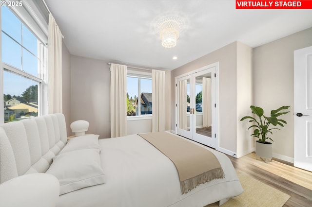 bedroom with access to exterior, wood finished floors, a chandelier, recessed lighting, and baseboards