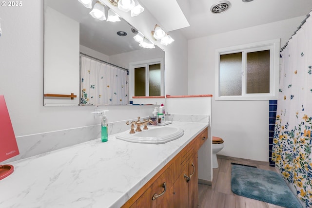 bathroom featuring toilet, visible vents, a shower with shower curtain, and vanity