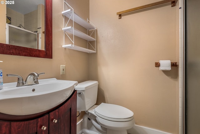 bathroom with toilet, a stall shower, and vanity