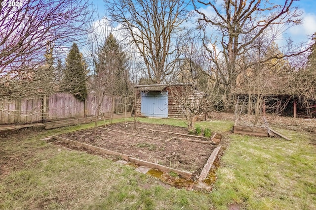 view of yard with a vegetable garden, fence, an outdoor structure, and a shed