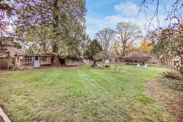 view of yard featuring an outdoor structure and fence