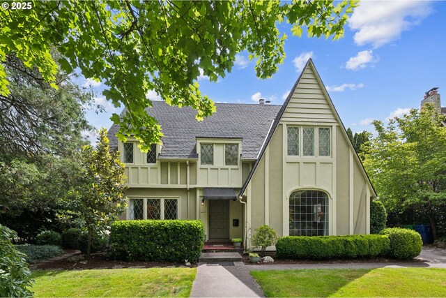 7150 SE 27th Ave, Portland, OR 97202 - english style home with roof with shingles, a front lawn, and stucco siding
