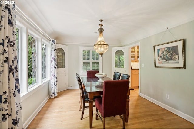 7150 SE 27th Ave, Portland, OR 97202 - dining space with light wood-style floors, a chandelier, and ornamental molding