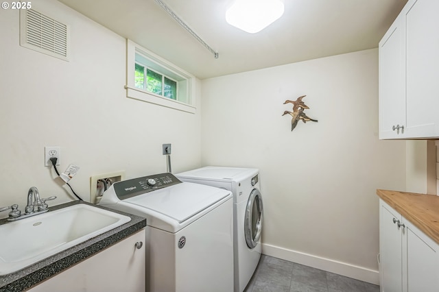 7150 SE 27th Ave, Portland, OR 97202 - laundry area featuring cabinet space, washer and clothes dryer, and light tile patterned floors