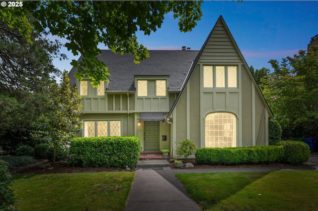 7150 SE 27th Ave, Portland, OR 97202 - tudor-style house featuring roof with shingles, a front yard, and stucco siding