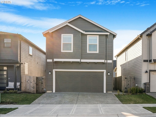 view of front of home featuring driveway, an attached garage, and fence