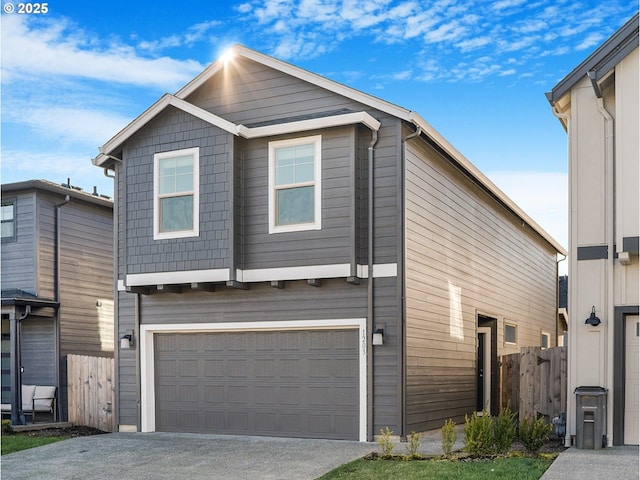 view of front of property with a garage, concrete driveway, and fence