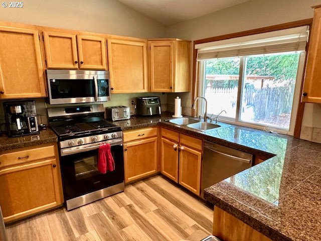 4120 NE 52nd St, Vancouver, WA 98661 - kitchen featuring stainless steel appliances, tile countertops, lofted ceiling, and light wood-style floors