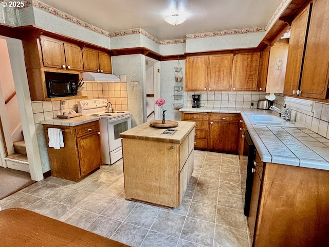991 Polk St, Eugene, OR 97402 - kitchen featuring electric stove, extractor fan, tile countertops, black microwave, and backsplash