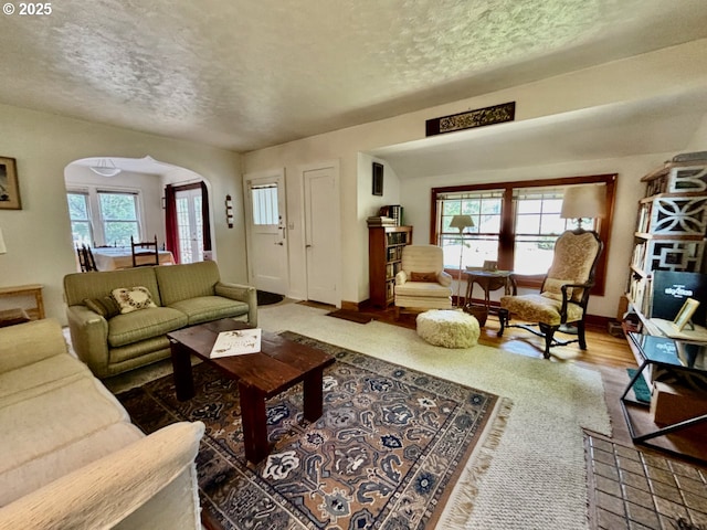991 Polk St, Eugene, OR 97402 - living area with arched walkways, a textured ceiling, and wood finished floors