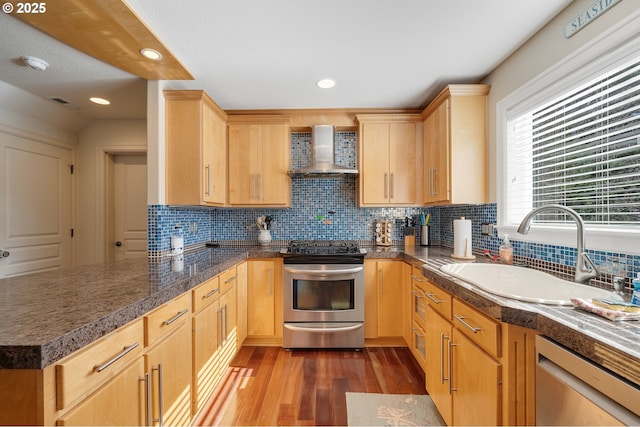 17460 Old Pacific Hwy, Rockaway Beach, OR 97136 - kitchen with wall chimney exhaust hood, stainless steel appliances, a sink, wood finished floors, and tasteful backsplash
