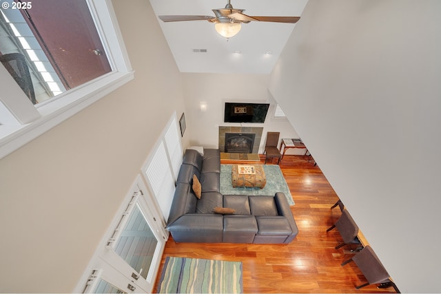 17460 Old Pacific Hwy, Rockaway Beach, OR 97136 - living room with a towering ceiling, plenty of natural light, wood finished floors, a ceiling fan, and a tiled fireplace