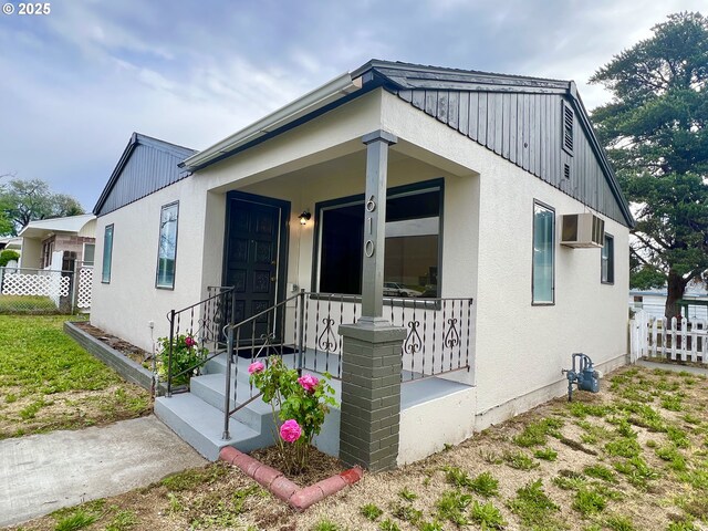 610 NE N St, Hermiston, OR 97838 - view of front of house featuring fence, stucco siding, and an AC wall unit