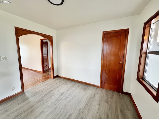 610 NE N St, Hermiston, OR 97838 - spare room with light wood-type flooring, arched walkways, and baseboards