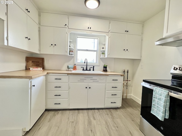 610 NE N St, Hermiston, OR 97838 - kitchen featuring stainless steel electric range, a sink, light wood-style floors, and white cabinetry