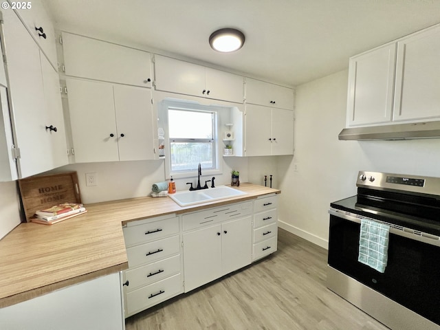 610 NE N St, Hermiston, OR 97838 - kitchen with stainless steel range with electric stovetop, under cabinet range hood, a sink, light wood finished floors, and light countertops